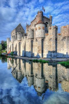 an old castle is reflected in the water