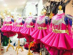 several pink dresses are on display in a store