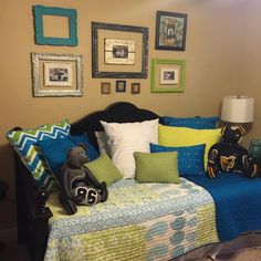 a living room filled with lots of furniture and pictures on the wall above it's headboard