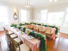 a long table is set up with pink and green linens for a formal function