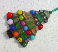 an ornament shaped like a fish with lots of colorful beads on it's back