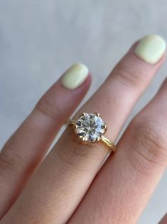 a woman's hand with a ring on it and a diamond in the middle