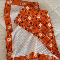 two orange and white squares with paw prints on them are laying next to each other