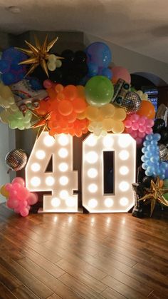 the number forty sits in front of balloons and streamers that spell out'40 '