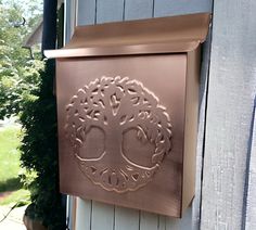 a metal plaque on the side of a house with a tree in it's center