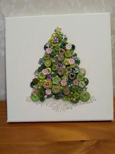 a christmas tree made out of buttons on a white box