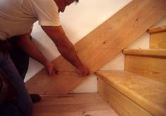 a man is working on some wooden stairs