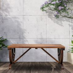 a wooden bench sitting on top of a wooden floor next to a plant filled wall