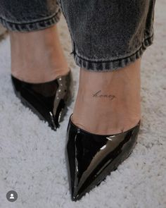 a woman's foot with a small tattoo on her ankle