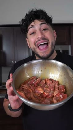 a man holding a pan full of food in his hands and making a funny face