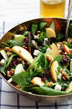 a salad with apples, spinach and walnuts