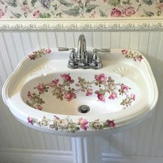 a white sink with flowers painted on it