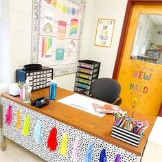 an office desk with lots of colorful pens and markers on the table next to it