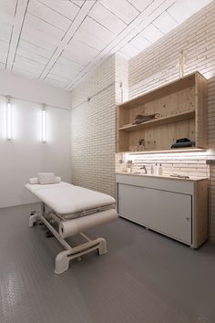 a hospital room with an empty bed in the middle and shelves on the wall behind it