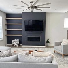 a living room with two couches and a television mounted on the wall in front of a fireplace