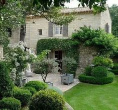 a large house with lots of trees and bushes around it's front lawn area