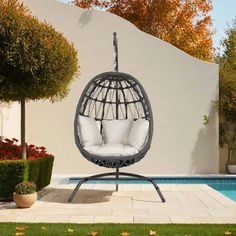 an outdoor swing chair next to a swimming pool