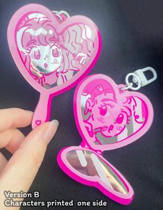 two pink heart shaped mirrors being held by someone's hand