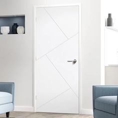 a white door in a living room next to two blue chairs and a book shelf