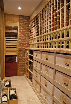 a wine cellar with lots of bottles in the wall and drawers on the floor next to it