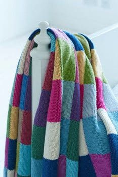 a multicolored blanket is hanging on a coat rack