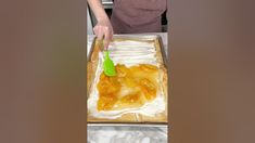 a woman is making a cake with fruit on it