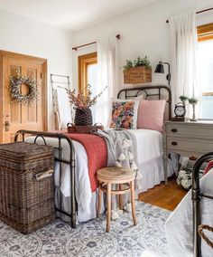 a bed room with a neatly made bed and two baskets on the side of it