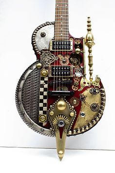 a miniature guitar made out of metal and gold parts on a white background with clippings