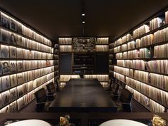 a room filled with lots of books next to a long table covered in white plates