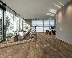 a living room filled with furniture and lots of glass doors on the side of it