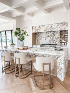 a kitchen with marble counter tops and white chairs