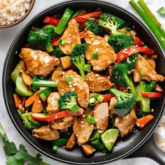 chicken and broccoli stir fry in a skillet with chopsticks on the side