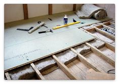 some tools are laying on the floor in an unfinished room