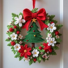 a crocheted christmas wreath with a red bow hanging from the front door, decorated with poinsettis and flowers