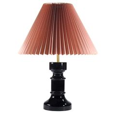 a black table lamp with a pink shade