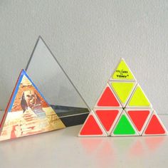 three different colored rubik cubes sitting on top of a white table next to each other