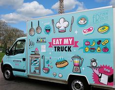 a food truck parked in front of the eiffel tower with stickers on it