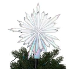 a white snowflake decoration sitting on top of a christmas tree