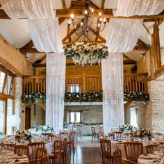 the inside of a wedding venue with chandeliers and tables set up for an event