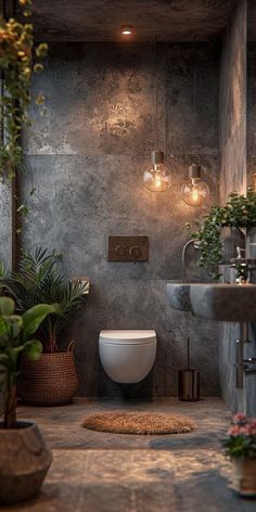 a bathroom that has plants in it and lights on the wall above the toilet bowl