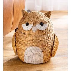 a woven owl basket sitting on the floor