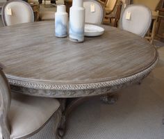 a wooden table with white chairs around it