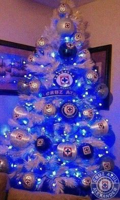 a blue christmas tree decorated with lights and ornaments