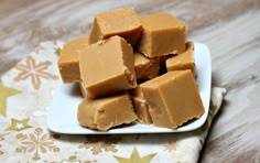 several pieces of peanut butter fudge on a small white plate with a floral napkin