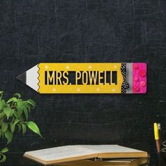 a yellow pencil with the word mrs power written on it next to an open book