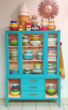 a blue china cabinet filled with lots of dishes