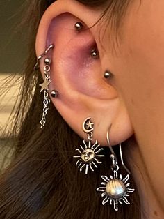 a close up of a person's ear with earrings on it and an eyeball in the middle