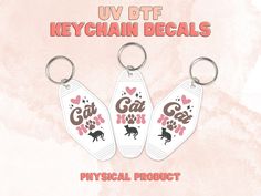 three keychain decals with cats and hearts on them are shown in pink