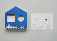 a small blue house next to a piece of paper