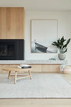 a living room with a couch, coffee table and fire place in front of a painting